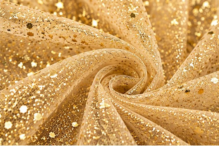 Dettaglio della trama a rete del tulle oro Aura con riflessi glitter luminosi