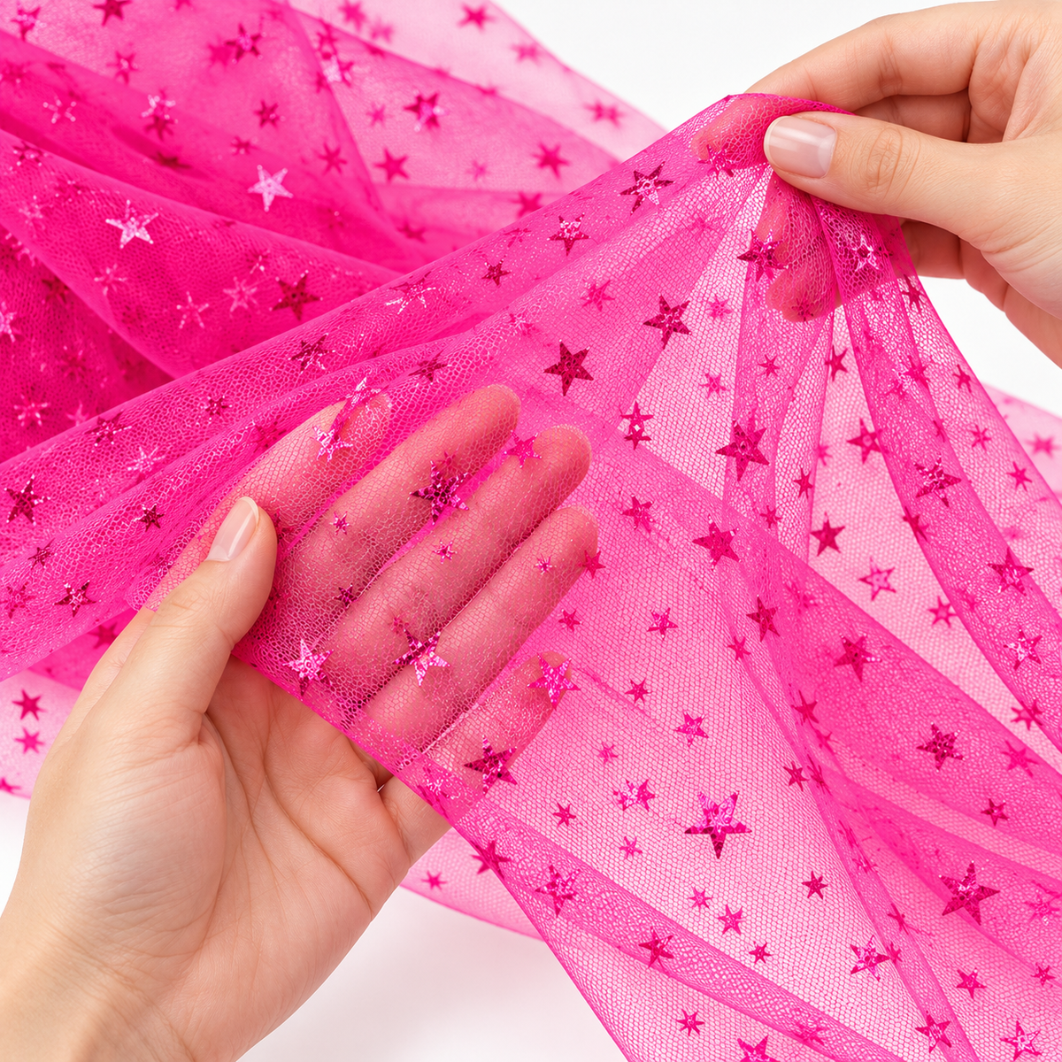 Tulle con stelline fucsia Aura mostrato tra le mani, dettaglio di trasparenza e texture